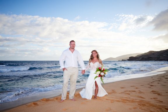 Sandy Beach Wedding Ceremony Couple in wedding attire walking hand in hand on a beach at sunset.