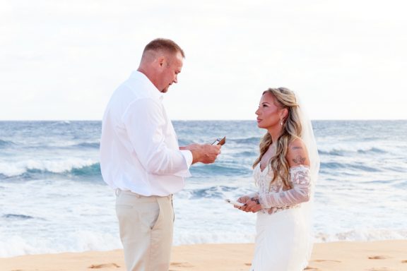 Sandy Beach Wedding Ceremony A couple exchanges vows on a beach during a wedding ceremony.