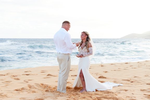 Sandy Beach Wedding Ceremony Couple in wedding attire exchanging vows on a beach at sunset.