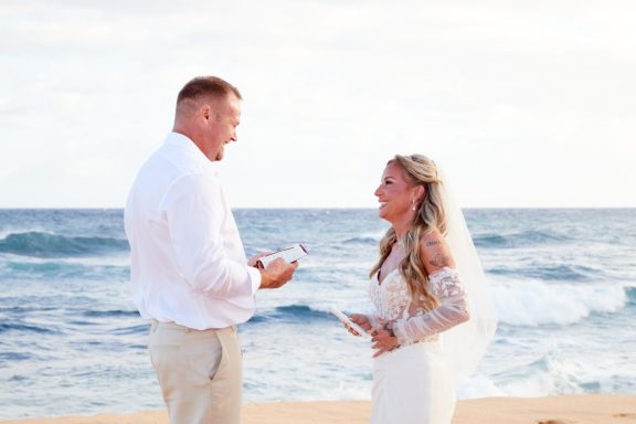 Sandy Beach Wedding Ceremony A couple exchanges vows on a beach with waves in the background.